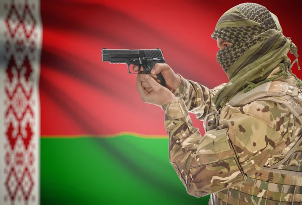 Male in muslim keffiyeh with gun in hand and national flag on background - Belarus — стокове фото
