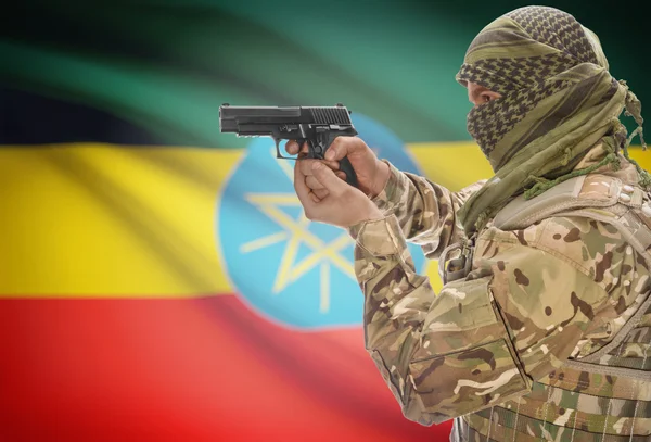 Male in muslim keffiyeh with gun in hand and national flag on background - Ethiopia — стокове фото