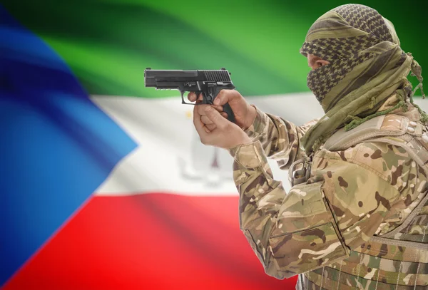 Male in muslim keffiyeh with gun in hand and national flag on background - Equatorial Guinea — Stock Fotó