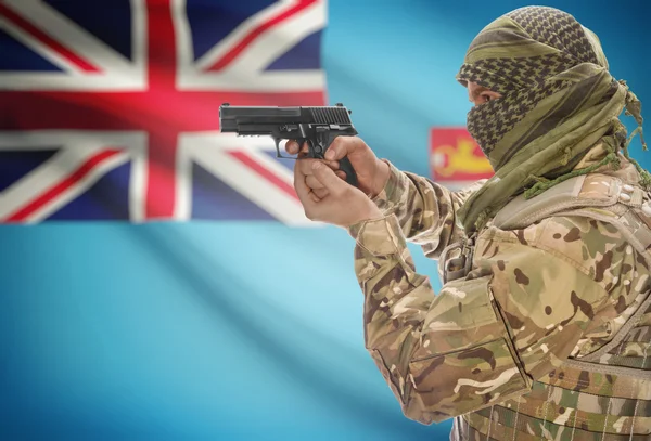 Male in muslim keffiyeh with gun in hand and national flag on background - Fiji — Zdjęcie stockowe