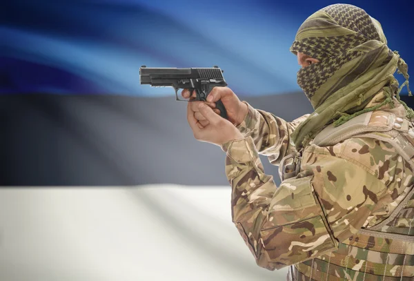 Male in muslim keffiyeh with gun in hand and national flag on background - Estonia — Stok fotoğraf