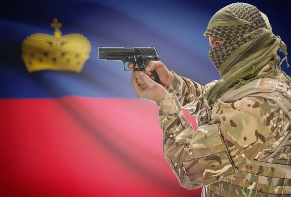 Male in muslim keffiyeh with gun in hand and national flag on background - Liechtenstein — стокове фото