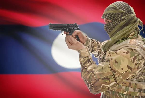 Male in muslim keffiyeh with gun in hand and national flag on background - Laos — Stok Foto