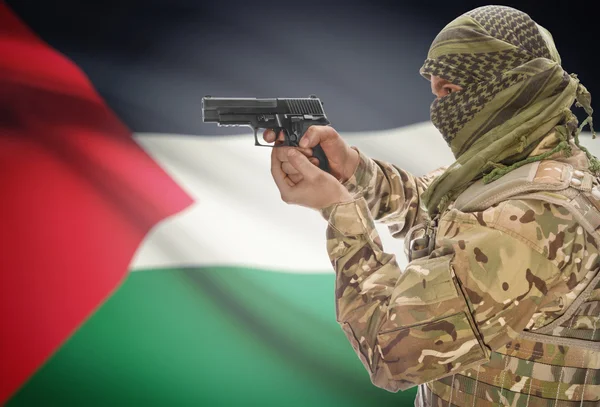 Male in muslim keffiyeh with gun in hand and national flag on background - Palestine — Fotografia de Stock