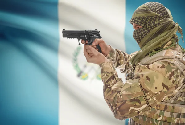 Homme en keffieh musulman avec un pistolet dans la main et le drapeau national sur le fond - Guatemala — Photo