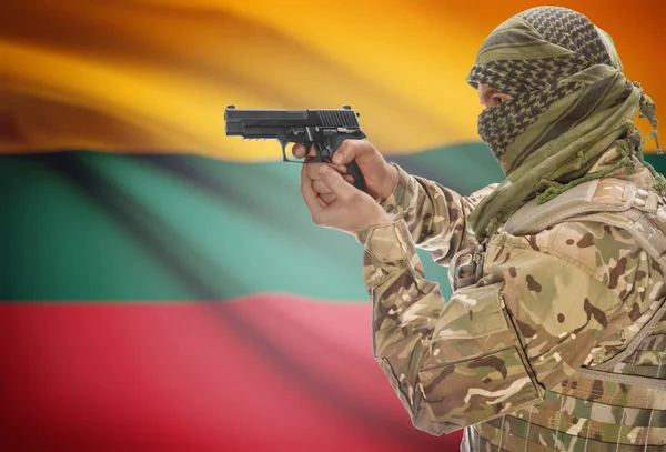 Male in muslim keffiyeh with gun in hand and national flag on background - Lithuania — стокове фото