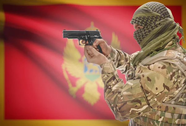 Male in muslim keffiyeh with gun in hand and national flag on background - Montenegro — стокове фото