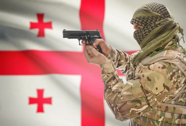 Male in muslim keffiyeh with gun in hand and national flag on background - Georgia — Stock Photo, Image