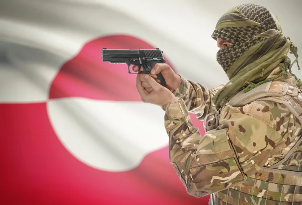 Male in muslim keffiyeh with gun in hand and national flag on background - Greenland — Stok fotoğraf