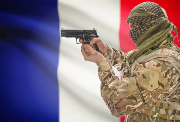 Male in muslim keffiyeh with gun in hand and national flag on background - France — Stok Foto