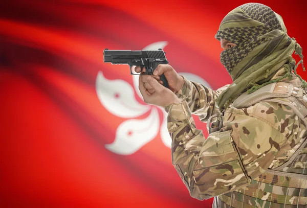 Male in muslim keffiyeh with gun in hand and national flag on background - Hong Kong — Stok fotoğraf