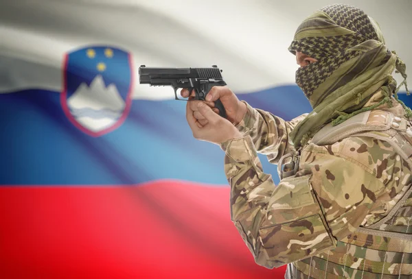 Male in muslim keffiyeh with gun in hand and national flag on background - Slovenia — Foto Stock