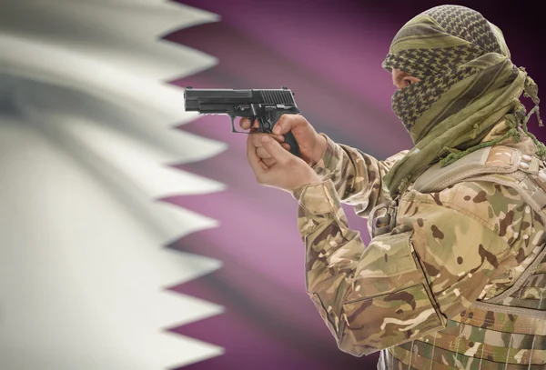Male in muslim keffiyeh with gun in hand and national flag on background - Qatar — Stok Foto