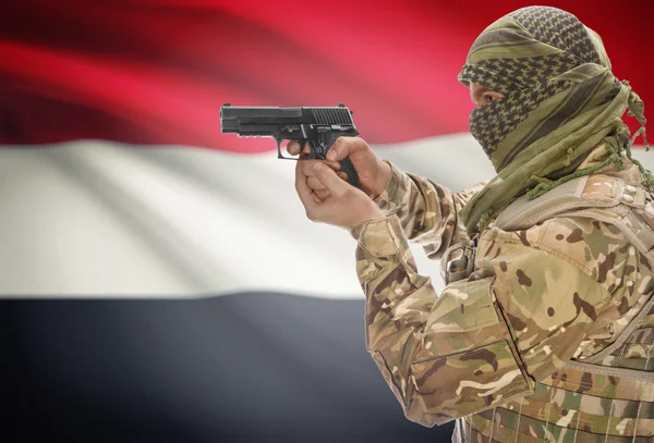 Male in muslim keffiyeh with gun in hand and national flag on background - Yemen — Stok Foto