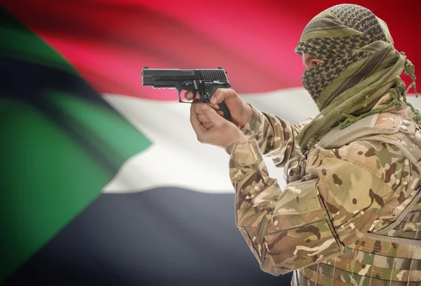 Male in muslim keffiyeh with gun in hand and national flag on background - Sudan — стокове фото