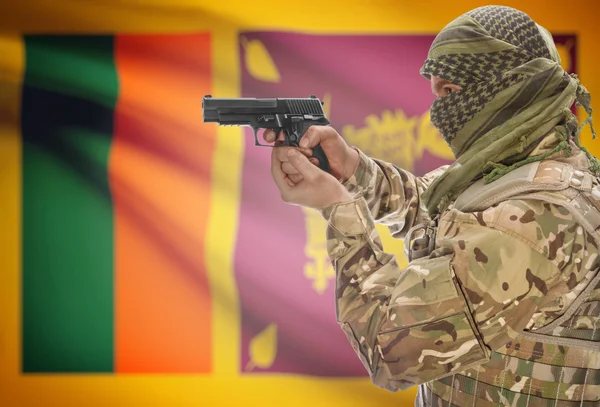 Male in muslim keffiyeh with gun in hand and national flag on background - Sri Lanka — 图库照片