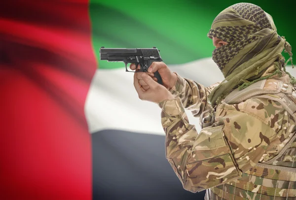 Male in muslim keffiyeh with gun in hand and national flag on background - United Arab Emirates — Stok Foto
