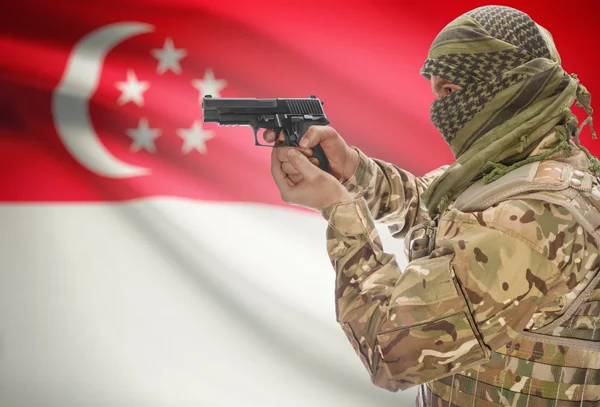Мужчина в мусульманскую куфия с пистолетом в руке и национальный флаг на фоне - Сингапур — стоковое фото
