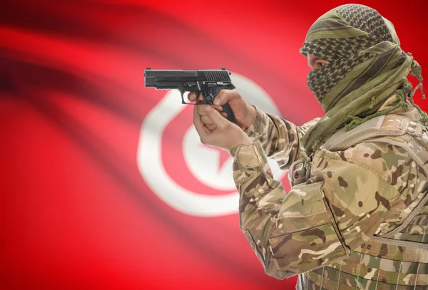 Male in muslim keffiyeh with gun in hand and national flag on background - Tunisia — Stok Foto