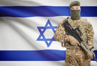Soldier holding machine gun with flag on background series - Israel