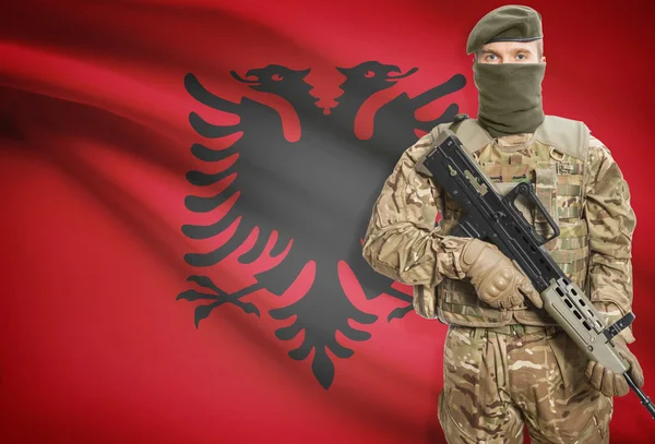 Soldier holding machine gun with flag on background series - Albania — Stock Photo, Image