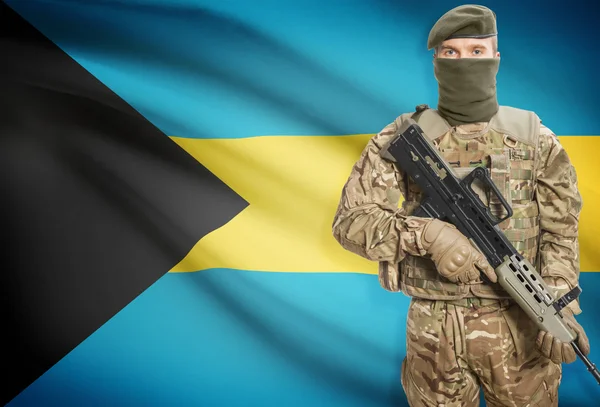 Soldier holding machine gun with flag on background series - Bahamas — Stockfoto