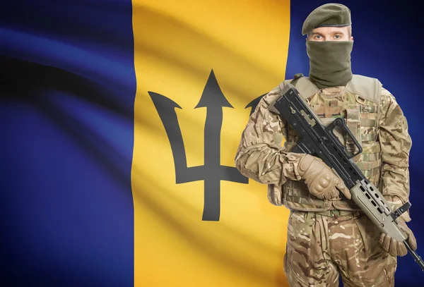 Soldier holding machine gun with flag on background series - Barbados — стокове фото