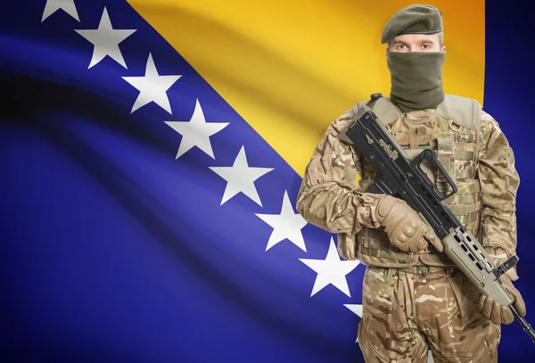 Soldier holding machine gun with flag on background series - Bosnia and Herzegovina — Foto de Stock