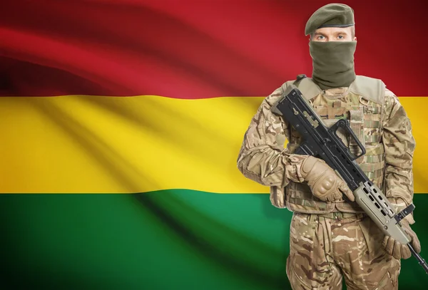 Soldier holding machine gun with flag on background series - Bolivia — Stockfoto
