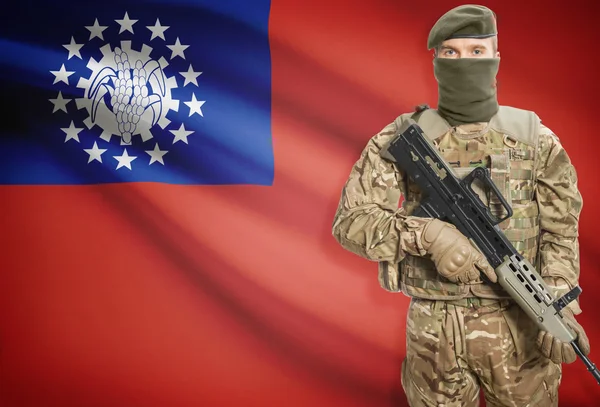 Soldier holding machine gun with flag on background series - Burma — Φωτογραφία Αρχείου