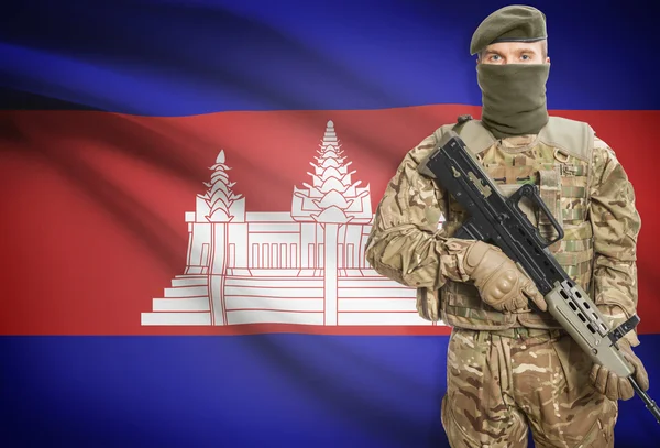 Soldier holding machine gun with flag on background series - Cambodia — Stockfoto