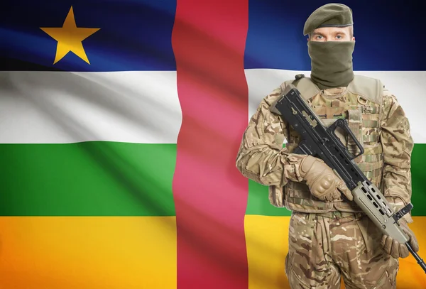 Soldier holding machine gun with flag on background series - Central African Republic — Zdjęcie stockowe