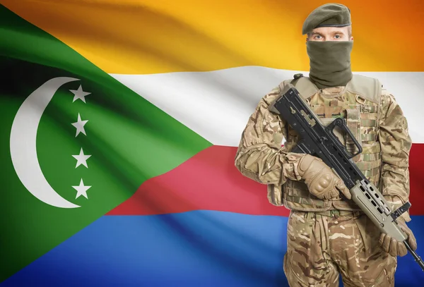 Soldier holding machine gun with flag on background series - Comoros — Stok Foto