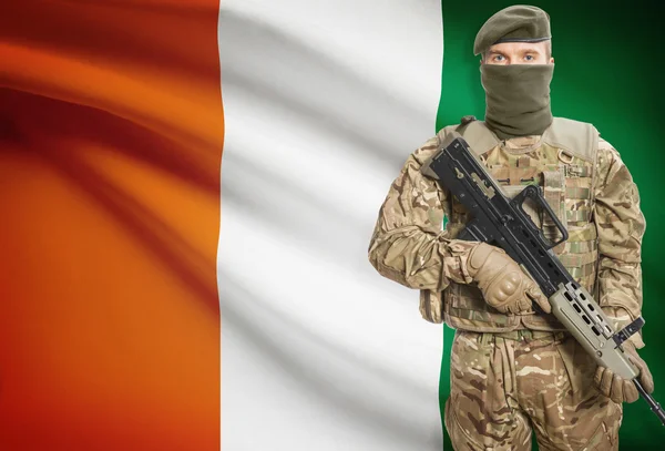 Soldier holding machine gun with flag on background series - Ivory Coast — Stockfoto
