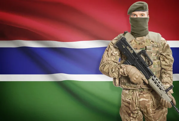 Soldier holding machine gun with flag on background series - Gambia — Stockfoto