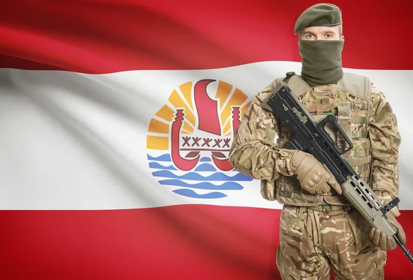 Soldier holding machine gun with flag on background series - French Polynesia — Stok Foto