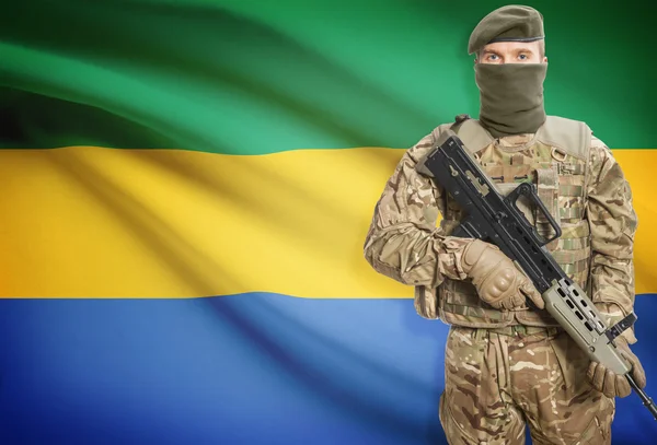 Soldat tenant une mitrailleuse avec le drapeau sur les séries de fond - Gabon — Photo