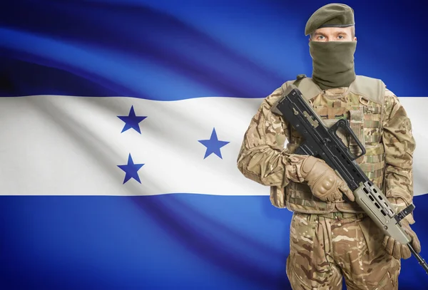 Soldier holding machine gun with flag on background series - Honduras — Stok Foto