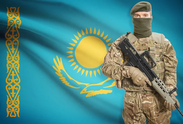 Soldier holding machine gun with flag on background series - Kazakhstan — стокове фото