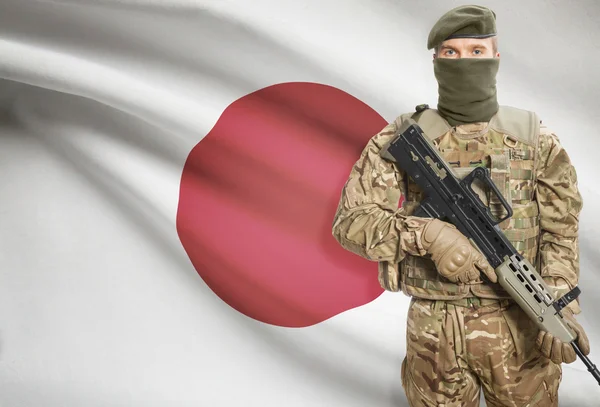 Солдат держит пулемет с флагом на фоне серии - Япония — стоковое фото