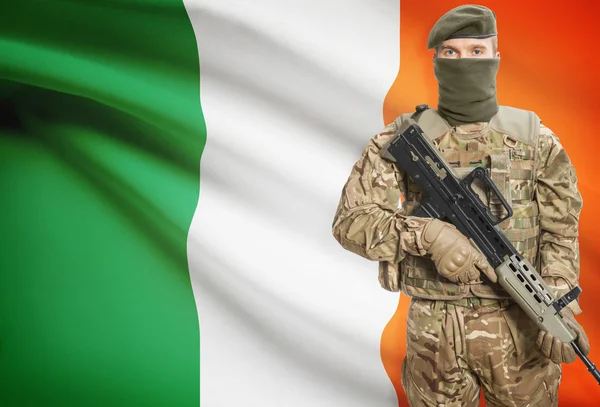 Soldier holding machine gun with flag on background series - Ireland — Stockfoto