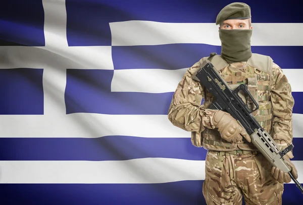 Soldier holding machine gun with flag on background series - Greece — Stock Photo, Image