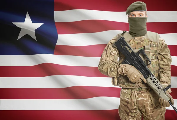 Soldier holding machine gun with flag on background series - Liberia — Stok Foto