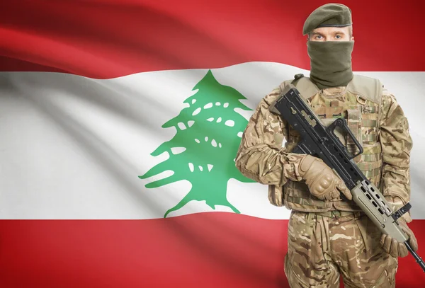 Soldier holding machine gun with flag on background series - Lebanon — Stock Photo, Image