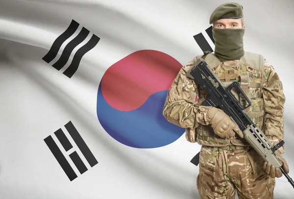 Soldier holding machine gun with flag on background series - South Korea — Stockfoto