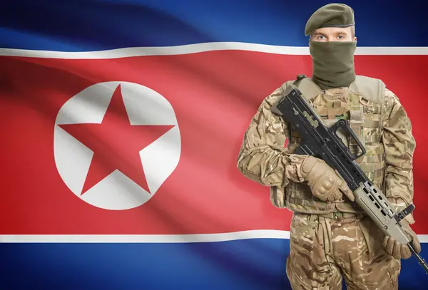 Soldier holding machine gun with flag on background series - North Korea — 스톡 사진