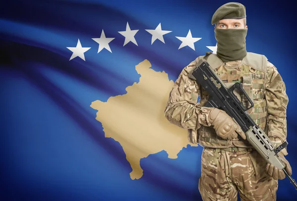 Soldier holding machine gun with flag on background series - Kosovo — Stok Foto