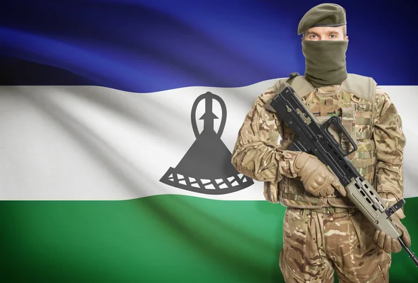 Soldat tenant une mitrailleuse avec le drapeau sur les séries de fond - Lesotho — Photo