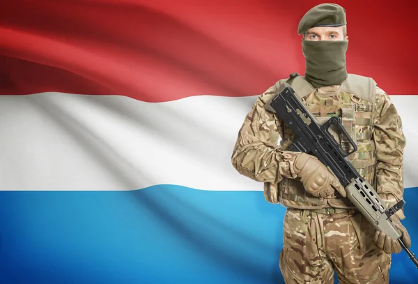 Soldier holding machine gun with flag on background series - Luxembourg — Stock Photo, Image