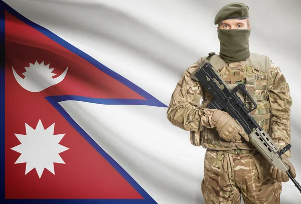 Soldier holding machine gun with flag on background series - Nepal — Stock Photo, Image